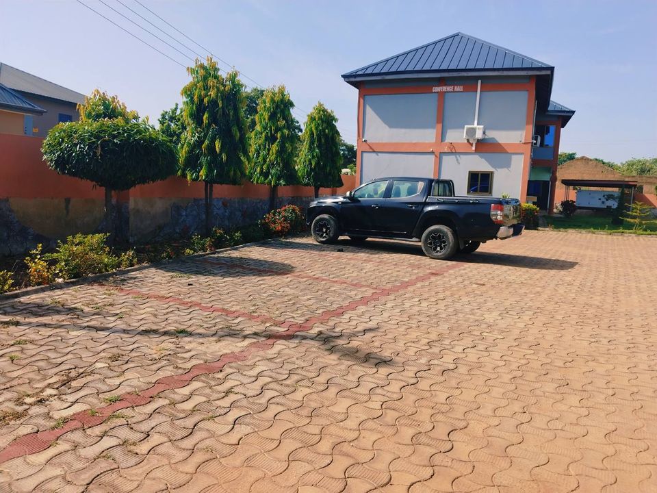 Two-storey lodge building with blue roof and paved courtyard